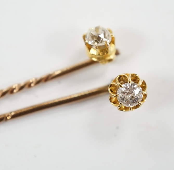 Two early 20th century yellow metal and solitaire diamond set stick pins, 65mm and a dress stud. Condition - fair to good